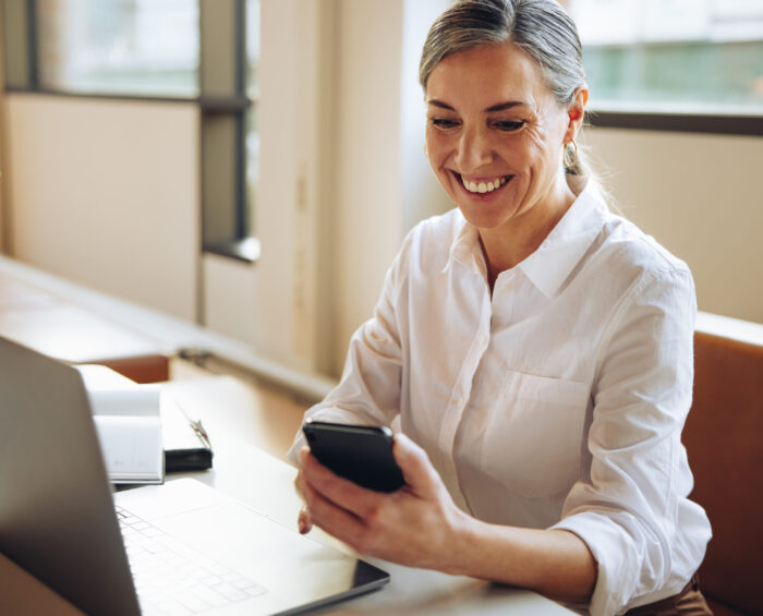 Vrouw aan het werk op haar telefoon en laptop