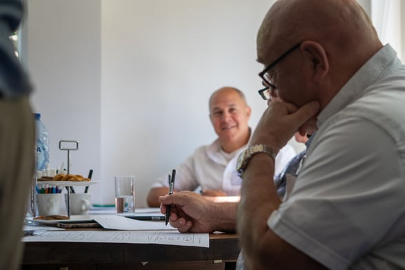 Klanten zitten aan tafel en maken een schets