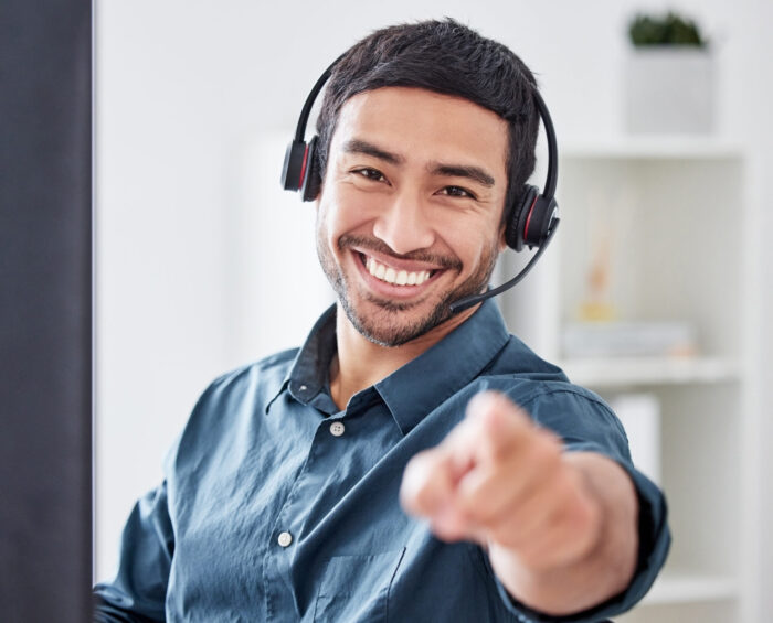 Man met headset op die naar de kijker wijst