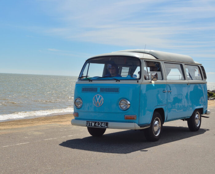 Een volkswagen busje dat langs de kust rijdt