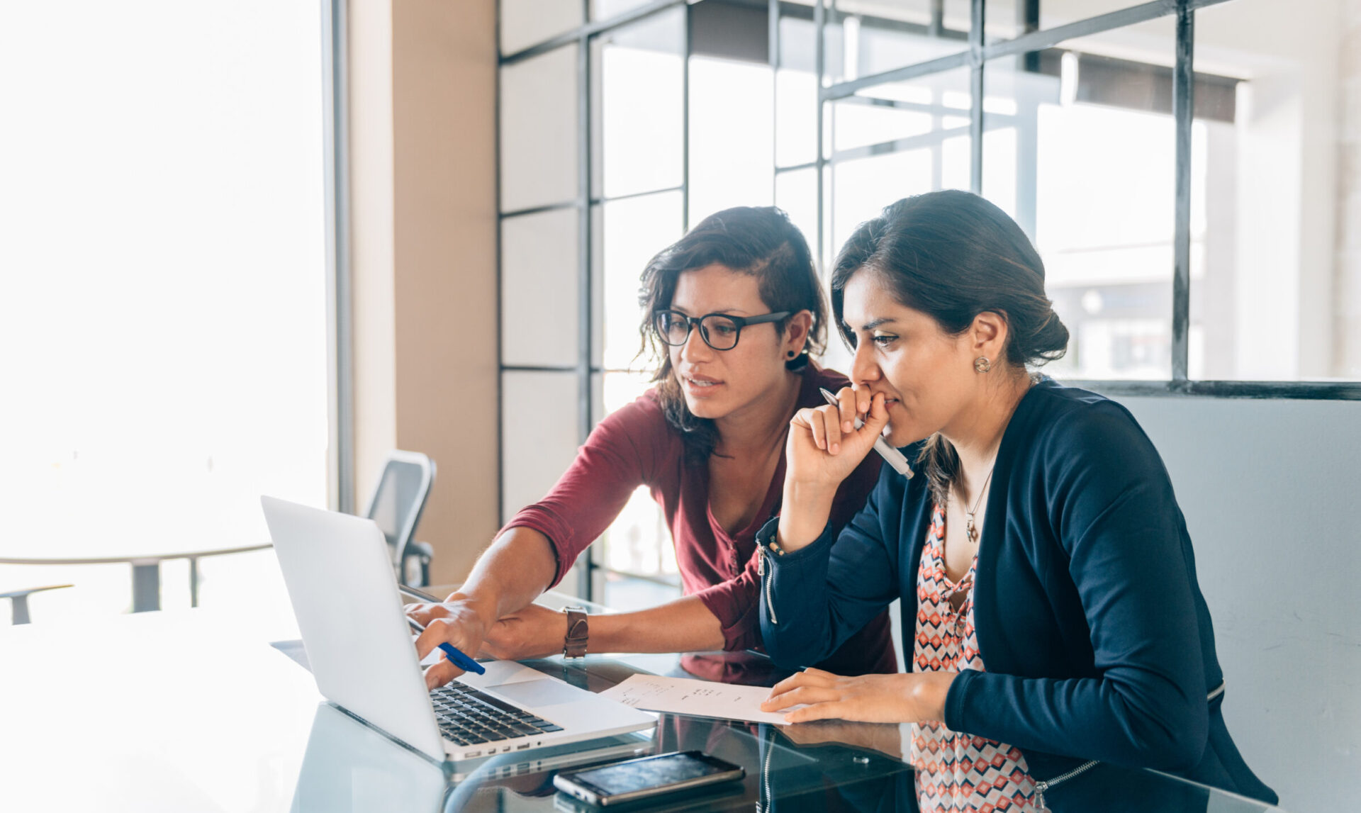 Twee vrouwen die samen naar een laptop kijken