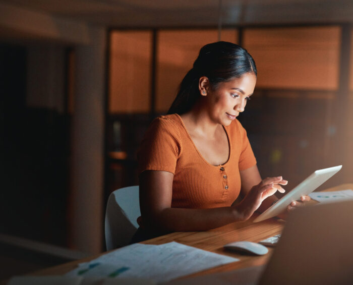 Vrouw die aan het werk is op haar tablet en computer