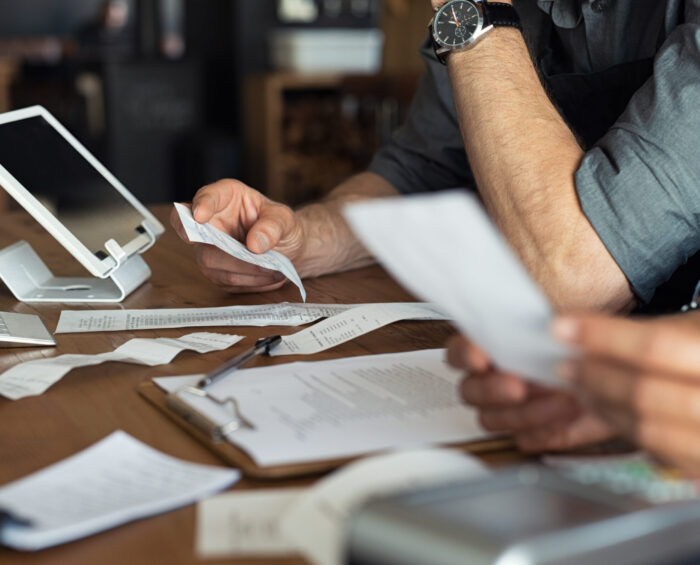 Twee mensen die bonnetjes en facturen verwerken voor de administratie