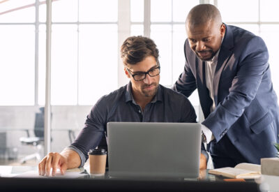 Collega's die samen achter een laptop werken