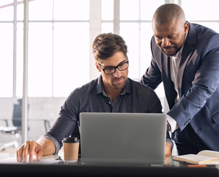 Collega's die samen achter een laptop werken