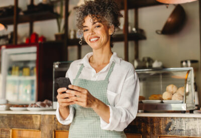 Cafe medewerker die op haar telefoon bezig is