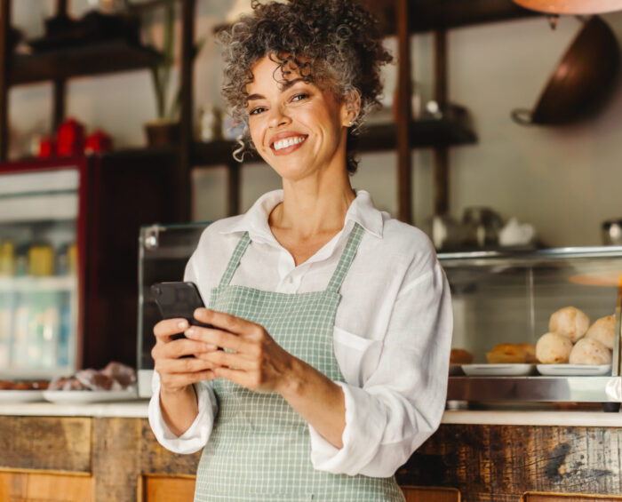 Cafe medewerker die op haar telefoon bezig is