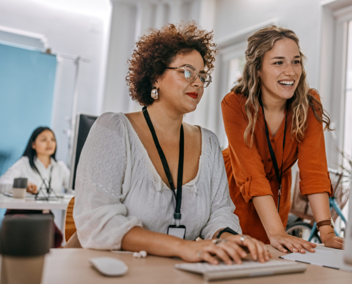 Twee collega's die samen naar een beeldscherm kijken